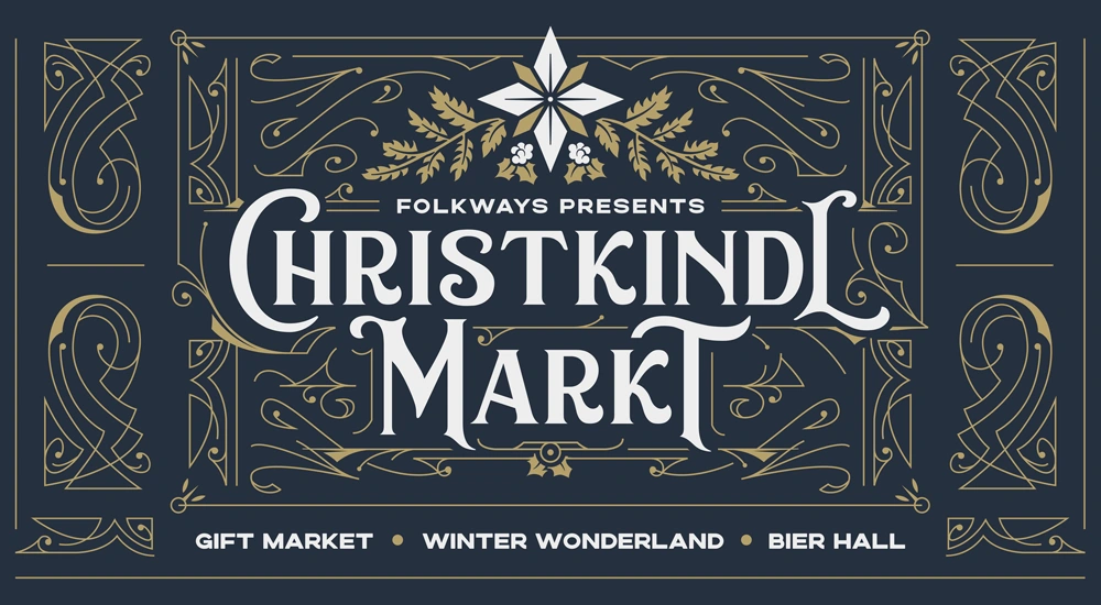 Dark blue logo image of Christkindlmarkt in white type. logo has a floral element above it in tan and white.