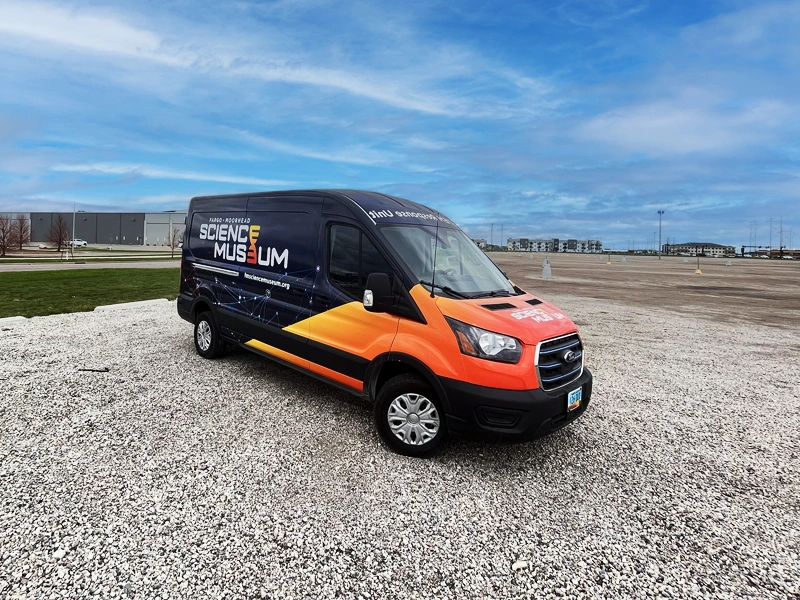 STEM Response Unit Van Image. Van is wrapped with FMSM logo on the side with a red to yellow gradient across the hood and onto the sides of the van.